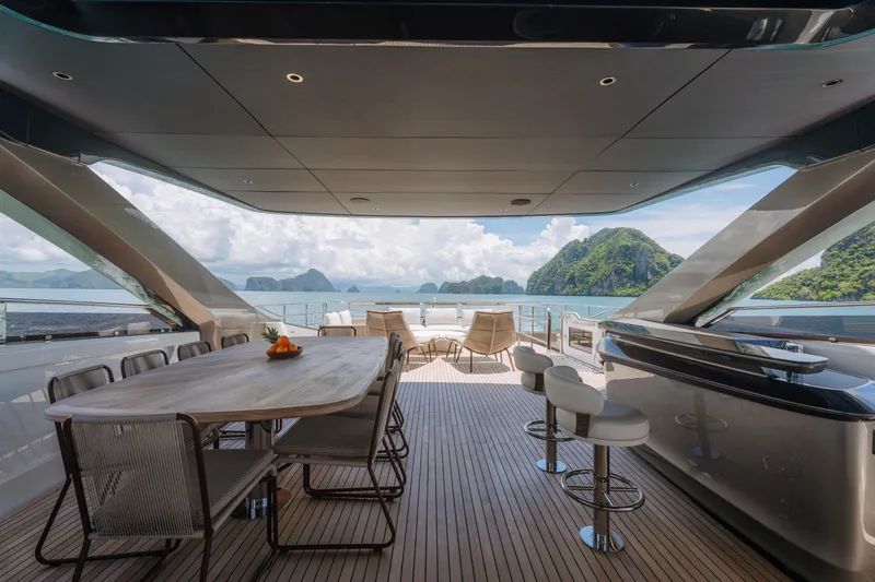  Yacht Photos Pics Luxurious 2023 Princess Y95 yacht deck with elegant seating, ocean view, and scenic islands.