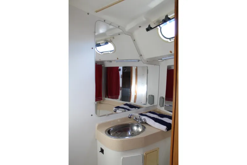 Cuckoo's Nest II Yacht Photos Pics Catalina MkII 2002 yacht bathroom with sink, mirror, and porthole window.