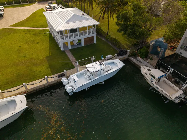  Yacht Photos Pics Aerial view of a 2024 Freeman 38 boat docked near a waterfront house.