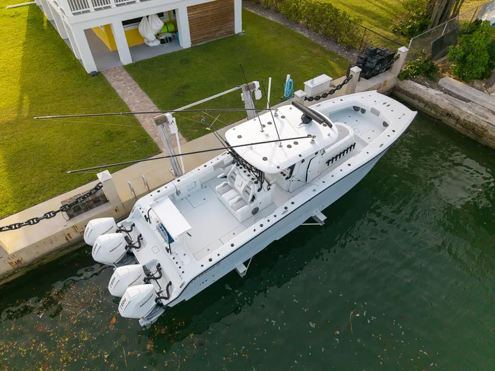  Yacht Photos Pics 2024 Freeman 38 boat docked by a waterfront home, featuring triple outboard engines.