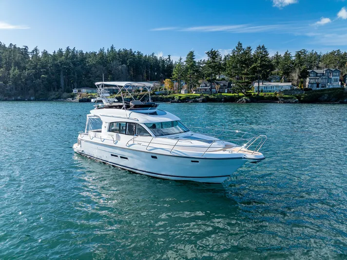 Duet Yacht Photos Pics 2024 Nimbus 405 Flybridge yacht cruising on a scenic lake with forested shoreline.