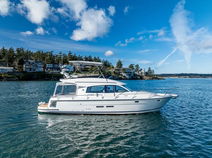 Duet Yacht Photos Pics 2024 Nimbus 405 Flybridge yacht cruising on a serene lake under a clear blue sky.