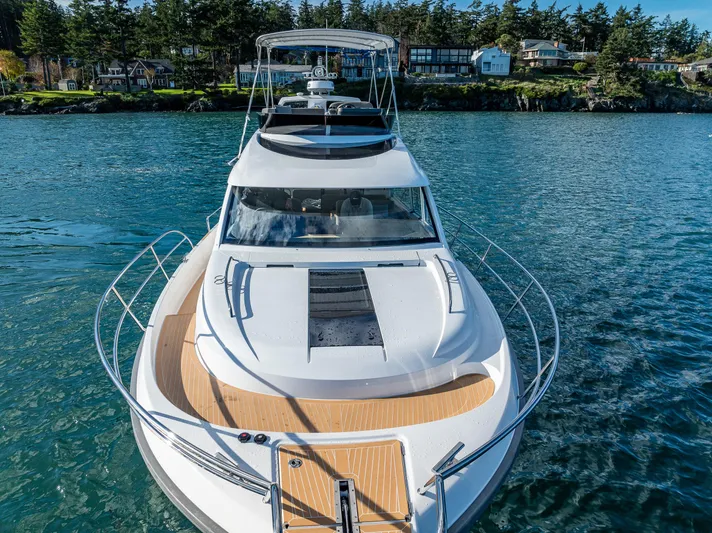 Duet Yacht Photos Pics 2024 Nimbus 405 Flybridge yacht on serene water, surrounded by lush greenery.