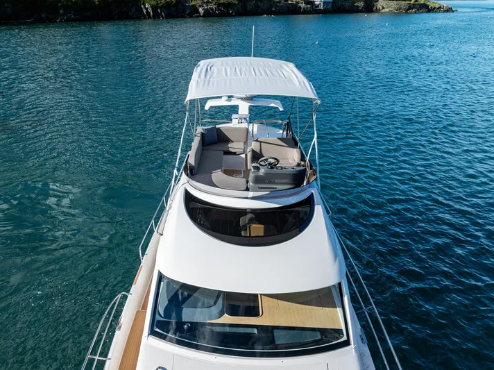 Duet Yacht Photos Pics 2024 Nimbus 405 Flybridge yacht on serene blue water, showcasing elegant design and spacious deck.