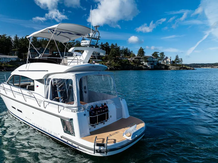 Duet Yacht Photos Pics 2024 Nimbus 405 Flybridge yacht on serene blue water under a clear sky.