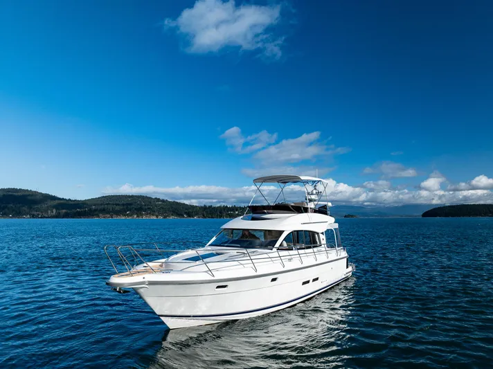 Duet Yacht Photos Pics 2024 Nimbus 405 Flybridge yacht cruising on a serene blue lake under a clear sky.