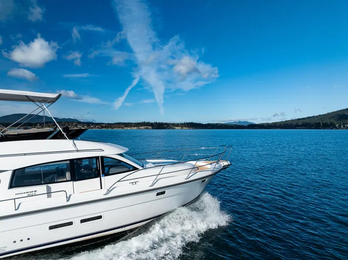 Duet Yacht Photos Pics 2024 Nimbus 405 Flybridge cruising on a serene blue lake under a clear sky.