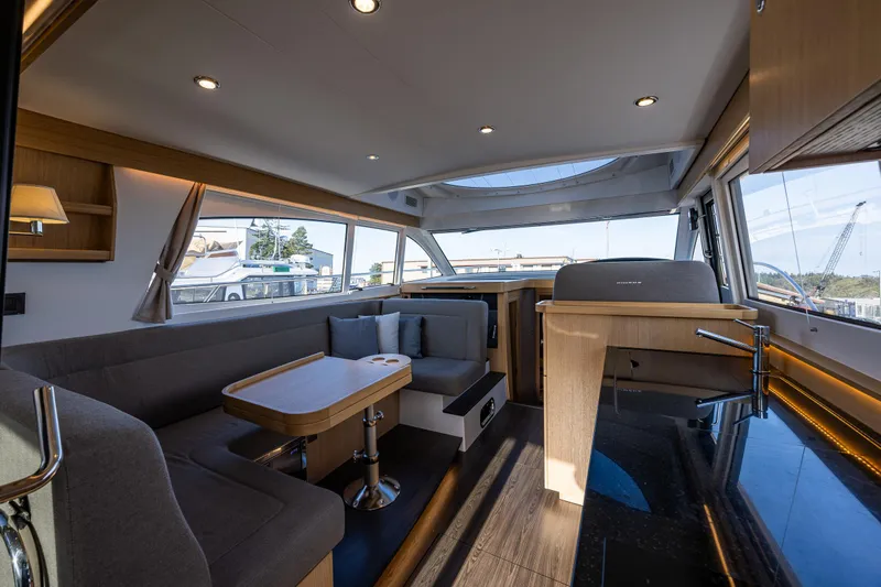Duet Yacht Photos Pics Luxurious interior of 2024 Nimbus 405 Flybridge yacht with modern seating and panoramic windows.