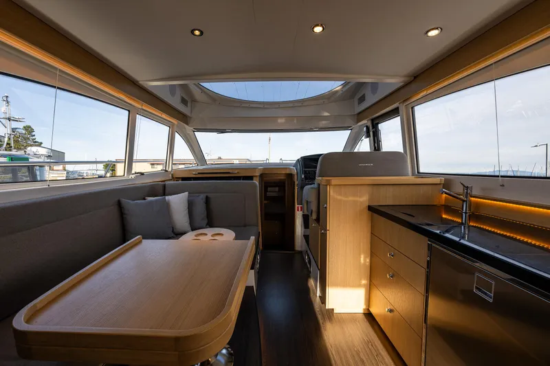 Duet Yacht Photos Pics Luxurious interior of 2024 Nimbus 405 Flybridge yacht with modern kitchen and seating area.