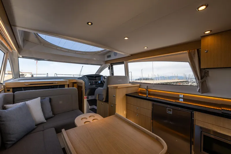 Duet Yacht Photos Pics Luxurious interior of 2024 Nimbus 405 Flybridge yacht with modern kitchen and seating area.