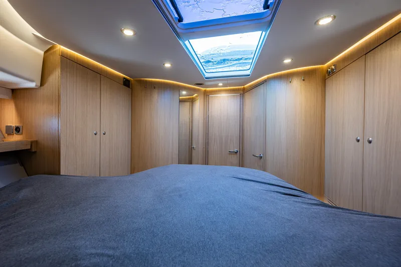 Duet Yacht Photos Pics Luxurious cabin interior of 2024 Nimbus 405 Flybridge with skylight and wooden cabinetry.