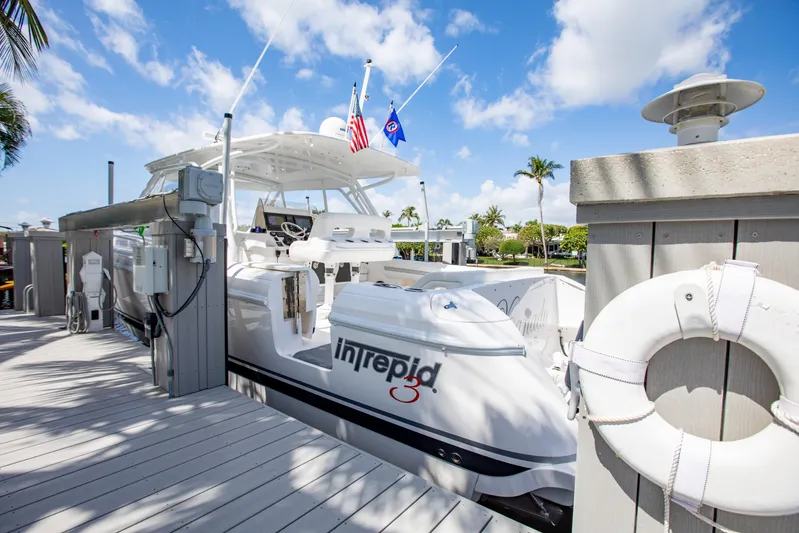  Yacht Photos Pics 2016 Intrepid 400 Cuddy docked, featuring sleek design and vibrant flags under a blue sky.