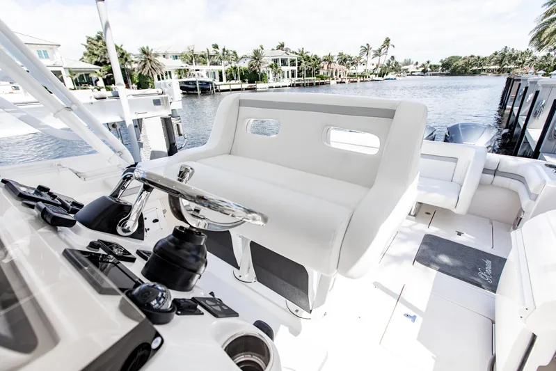  Yacht Photos Pics 2016 Intrepid 400 Cuddy boat interior with steering wheel and seating, docked by waterfront homes.