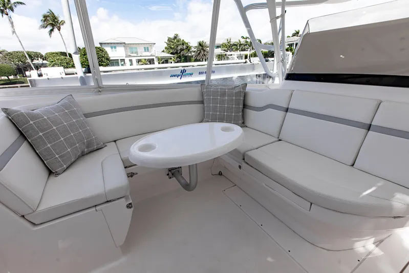 Yacht Photos Pics 2016 Intrepid 400 Cuddy boat interior with cushioned seating and round table.