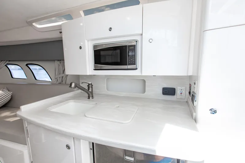  Yacht Photos Pics 2016 Intrepid 400 Cuddy interior with modern kitchenette, featuring sink and microwave.