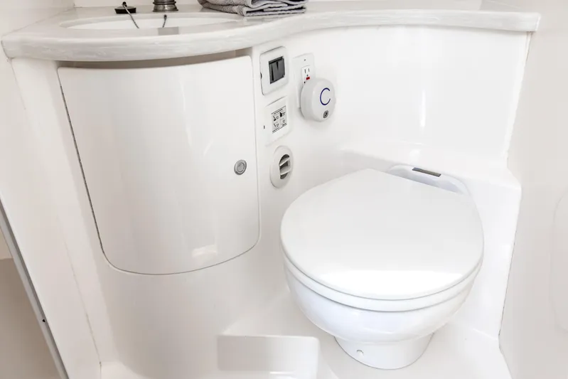  Yacht Photos Pics Compact marine bathroom in 2016 Intrepid 400 Cuddy, featuring toilet and sink.