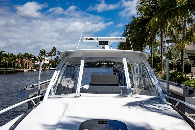  Yacht Photos Pics 2016 Intrepid 400 Cuddy boat docked by palm trees and waterfront homes.