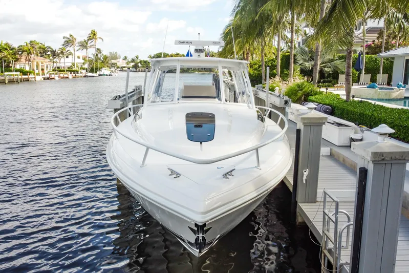  Yacht Photos Pics 2016 Intrepid 400 Cuddy boat docked by palm trees and waterfront homes.