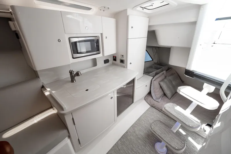  Yacht Photos Pics Interior of 2016 Intrepid 400 Cuddy featuring kitchenette and cozy seating area.