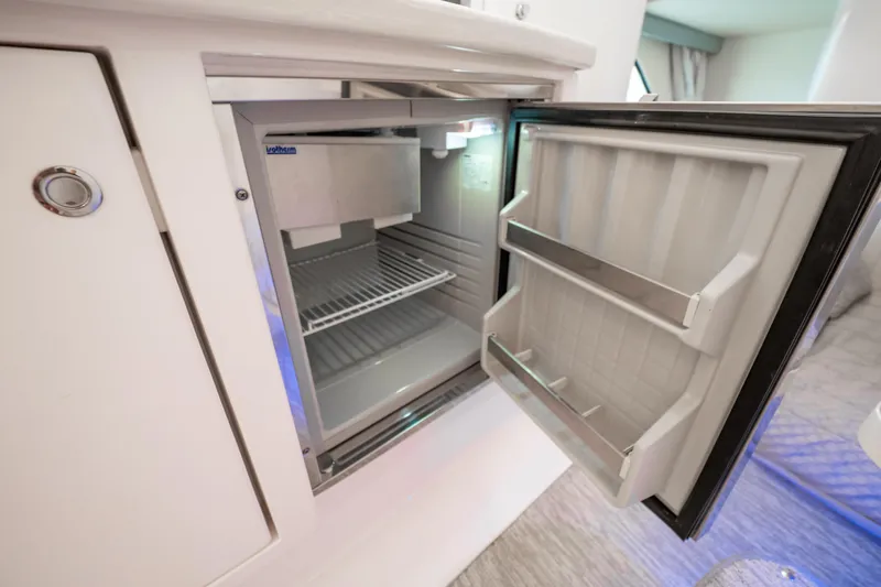  Yacht Photos Pics Open refrigerator inside 2016 Intrepid 400 Cuddy boat, showcasing interior storage space.