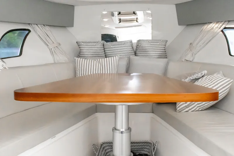  Yacht Photos Pics Interior of 2016 Intrepid 400 Cuddy with wooden table and cushioned seating.