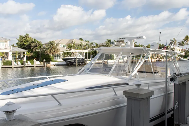  Yacht Photos Pics 2016 Intrepid 400 Cuddy boat docked by waterfront homes under a cloudy sky.