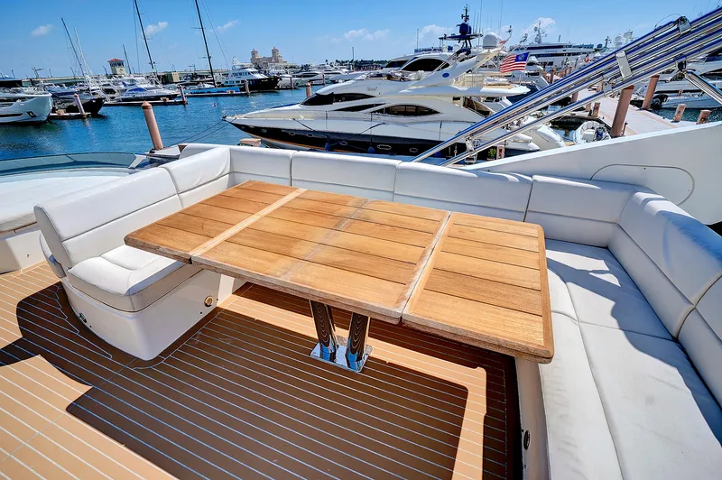 Once Around Yacht Photos Pics Sunseeker 68 Sport Yacht 2017, luxurious deck with wooden table and white seating, docked at marina.