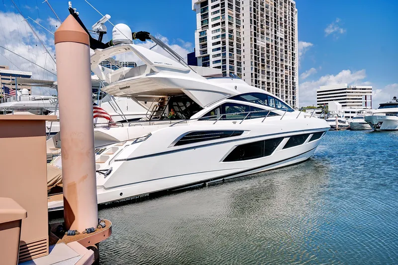 Once Around Yacht Photos Pics 2017 Sunseeker 68 Sport Yacht docked in a marina with cityscape background.