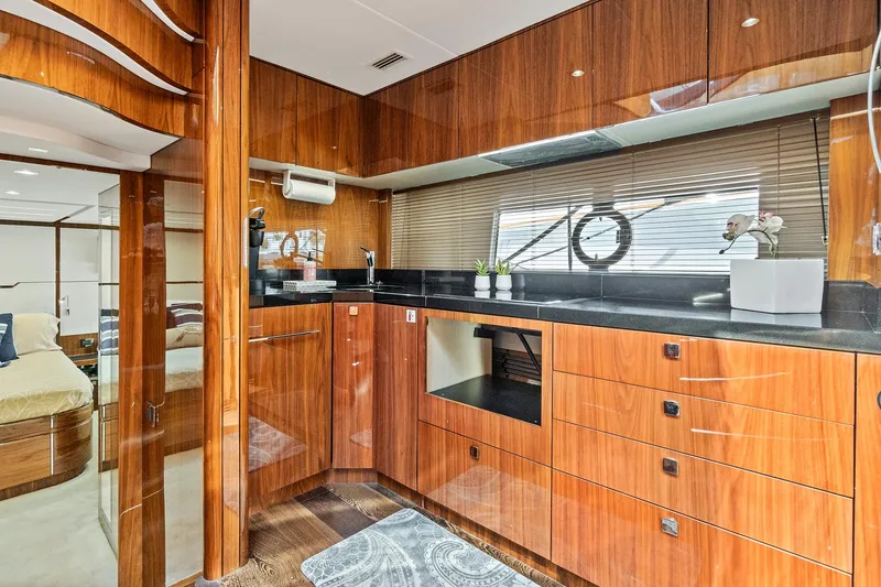 Once Around Yacht Photos Pics Luxurious kitchen interior of 2017 Sunseeker 68 Sport Yacht with wooden cabinetry and modern appliances.