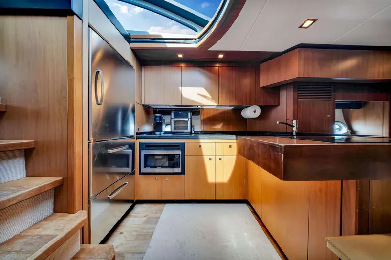 Jimbo Yacht Photos Pics Luxurious kitchen interior of 2012 Sunseeker 74 Sport Yacht with modern appliances and wood finish.