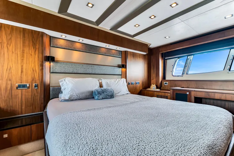 Jimbo Yacht Photos Pics Luxurious bedroom interior of 2012 Sunseeker 74 Sport Yacht with elegant wood finishes and large window.