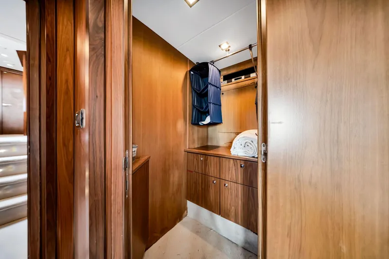 Jimbo Yacht Photos Pics Interior of 2012 Sunseeker 74 Sport Yacht with wooden cabinetry and hanging clothes.