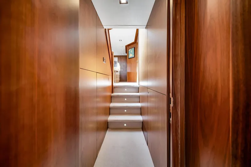 Jimbo Yacht Photos Pics Interior hallway of 2012 Sunseeker 74 Sport Yacht with wooden paneling and carpeted stairs.