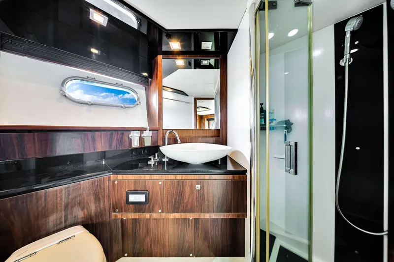 Jimbo Yacht Photos Pics Luxurious bathroom in 2012 Sunseeker 74 Sport Yacht with modern fixtures and elegant wood accents.