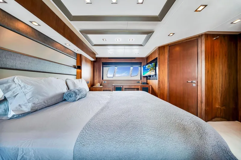 Jimbo Yacht Photos Pics Luxurious bedroom interior of 2012 Sunseeker 74 Sport Yacht with modern design and wood accents.