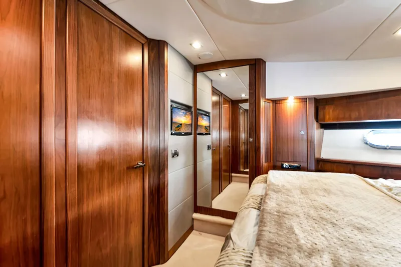 Jimbo Yacht Photos Pics Luxurious interior of 2012 Sunseeker 74 Sport Yacht with elegant wood paneling and cozy bedding.