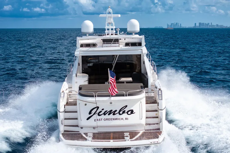 Jimbo Yacht Photos Pics Sunseeker 74 Sport Yacht 2012 cruising with American flag, ocean backdrop.