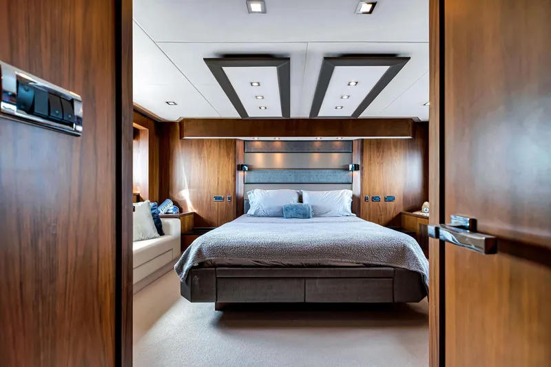 Jimbo Yacht Photos Pics Luxurious bedroom interior of 2012 Sunseeker 74 Sport Yacht with modern wood paneling.
