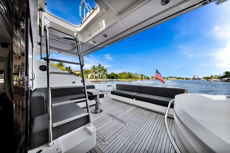 Jimbo Yacht Photos Pics Luxurious 2012 Sunseeker 74 Sport Yacht deck with seating, ladder, and scenic waterfront view.