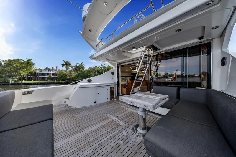 Jimbo Yacht Photos Pics Luxurious 2012 Sunseeker 74 Sport Yacht deck with seating, table, and scenic waterfront view.