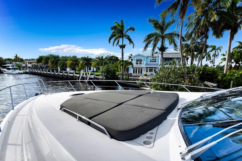 Jimbo Yacht Photos Pics Sunseeker 74 Sport Yacht 2012 on a scenic waterfront with palm trees and luxury homes.