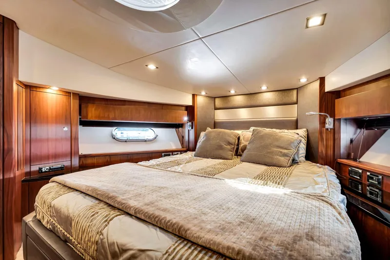 Jimbo Yacht Photos Pics Luxurious cabin interior of 2012 Sunseeker 74 Sport Yacht with elegant bedding and wood finishes.