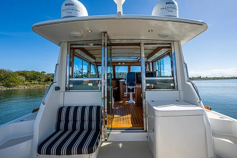  Yacht Photos Pics 2016 Sabre 42 Salon Express yacht with open cabin, striped seating, and scenic water view.