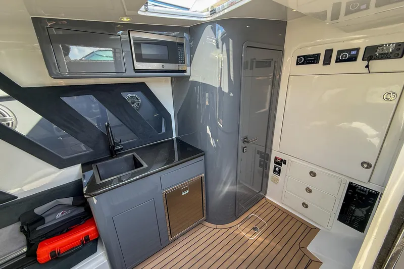  Yacht Photos Pics Luxurious interior of 2023 Midnight Express 43 Solstice boat with modern kitchenette and sleek design.