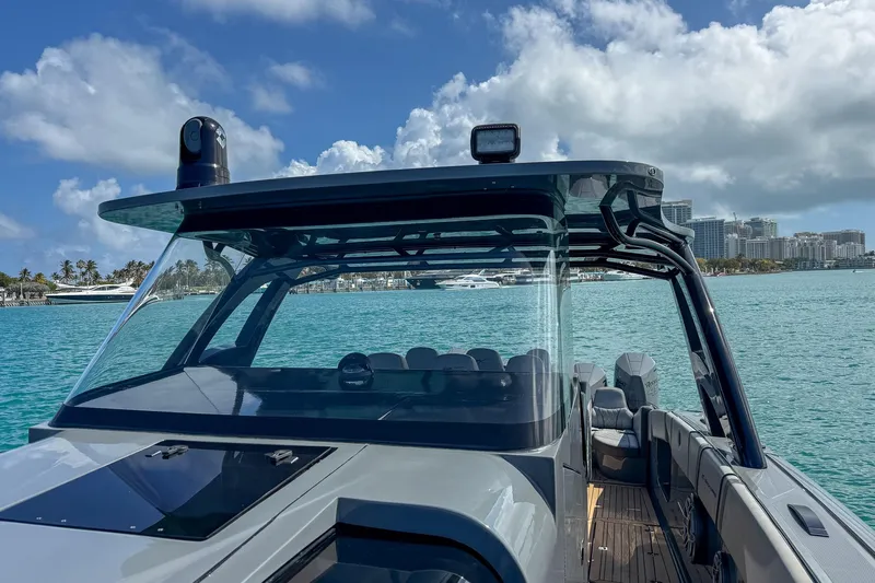 Yacht Photos Pics 2023 Midnight Express 43 Solstice boat on turquoise water with city skyline background.