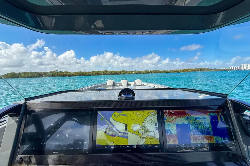  Yacht Photos Pics Cockpit view of 2023 Midnight Express 43 Solstice boat with navigation screens, on blue water.