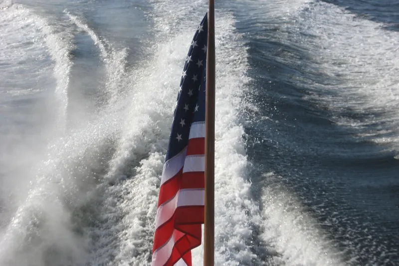 Off Islander Yacht Photos Pics American flag on 2007 Legacy Yachts 32, with ocean wake in the background.