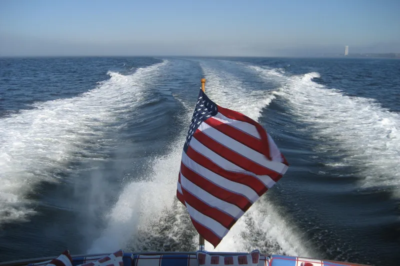Off Islander Yacht Photos Pics American flag on 2007 Legacy Yachts 32, cruising with ocean wake in background.