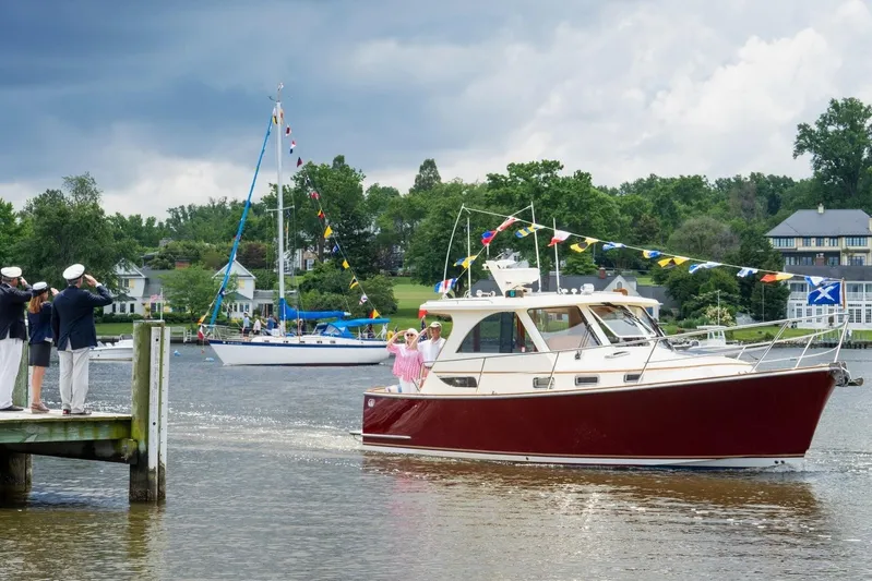 Off Islander Yacht Photos Pics 2007 Legacy Yachts 32 cruising on a scenic river, decorated with colorful flags.
