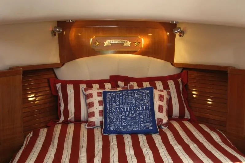 Off Islander Yacht Photos Pics Cozy cabin interior of 2007 Legacy Yachts 32 with striped bedding and decorative pillows.